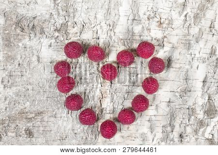 Red Raspberies In A Form Of Heart Laying On A Wooden Background
