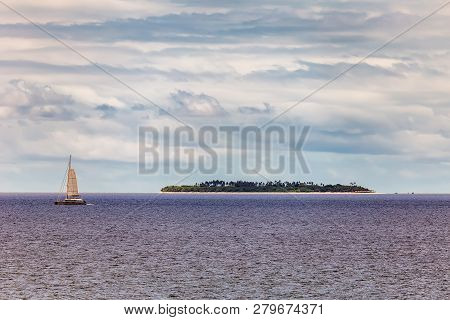 View A Small Tropical Island In The Background And A Yacht In The Foreground Next To Port Denarau, F