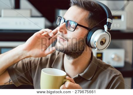 Man drinking coffee and listening to music being carried away by the sound