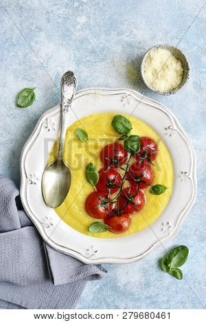 Traditional Italian Dish Polenta With Parmesan Cheese And Grilled Tomato.