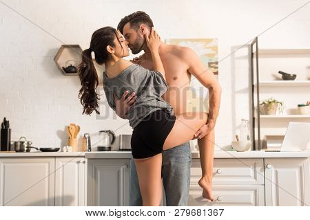 Selective Focus Of Young Seductive Couple Passionately Hugging In Kitchen At Home