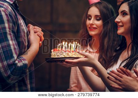 Attractive Brunette Woman Present Delicious Cake With Candles To The Birthday Man. Man In Flanel Shi