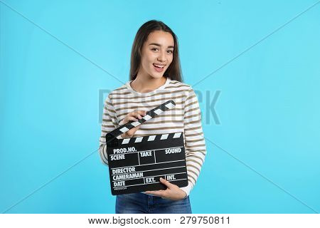 Woman With Clapperboard On Color Background. Cinema Show