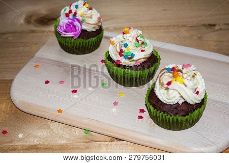 Muffins On A Wood Cutting Board. Cream Decoration. Place For Text.
