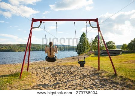 Young Woman On Swing In Oppstrynsvatn Lake In The Municipality Of Stryn In Sogn Og Fjordane County I