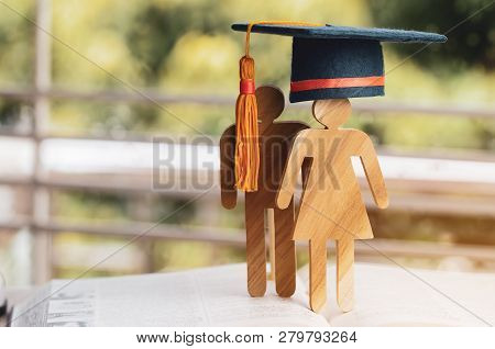 Back To School Concept, People Sign Wood With Graduation Celebrating Cap On Open Textbook With Light