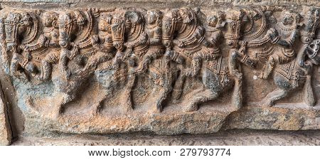 Belur, Karnataka, India - November 2, 2013: Brown Stone Plinth Sculpture Of Row Of Horses With Warri