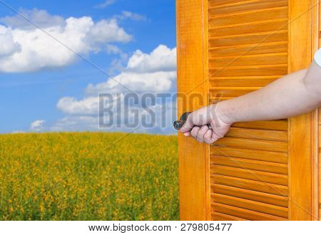 Man Hand Open Door Handle The Rocking Shaft Or Opens Empty Room Door To Nature And Yellow Flower Fie