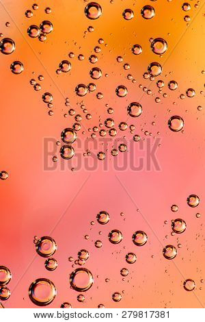 Macro Shot Of Backlit Gas-liquid Emulsion Over Colored Background. Tiny Gas Bubbles Inside Larger Oi