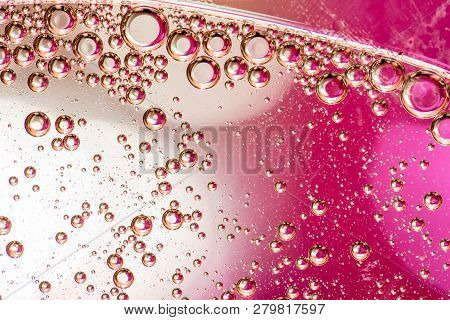 Macro Shot Of Backlit Gas-liquid Emulsion Over Colored Background. Gas Bubbles Inside Larger Oil Bas