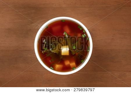 A Photo Of A Bowl Of Miso Shiru Soup With Tofu, Scallions, And Wakame Seaweed, Shot From Above On A 