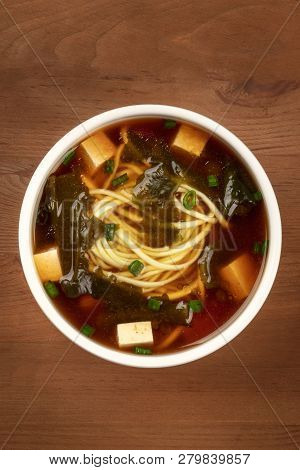 A Photo Of A Bowl Of Miso Shiru Soup With Tofu, Scallions, Noodles, And Wakame Seaweed, Shot From Th