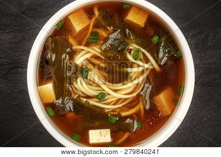 A Closeup Photo Of A Bowl Of Miso Shiru Soup With Tofu, Scallions, Noodles, And Wakame Seaweed, Shot