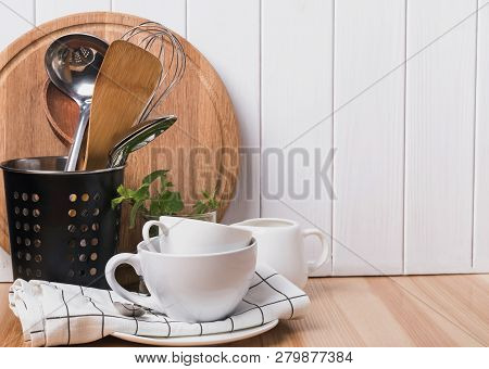 Cooking Utensils And Tableware Stnding On The Wooden Table.