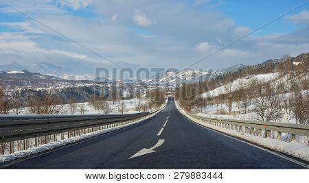 Classic Winter Scene Of A Road And Mountains In Rural Area