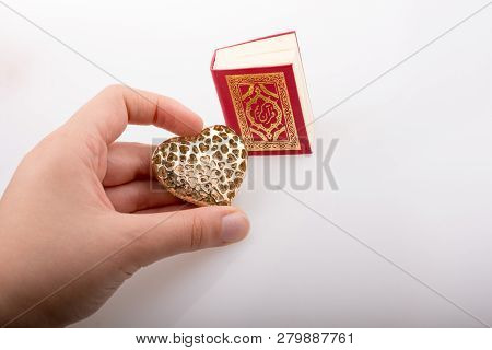 Hand Holding Heart Shape  And Islamic Holy Book Quran