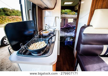 Cooking dinner or lunch in campervan, motorhome or RV. Preparing chicken  in a pan in camper van whe