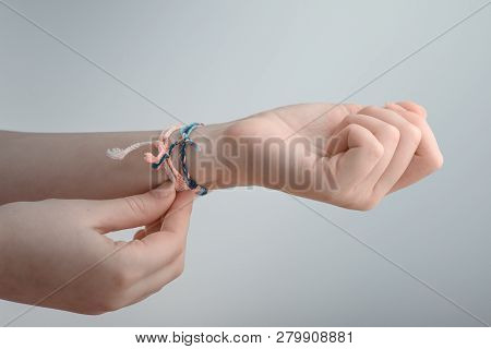 Horizontal Toned Shot Of A Female Hand Wearing Braided Bracelets.