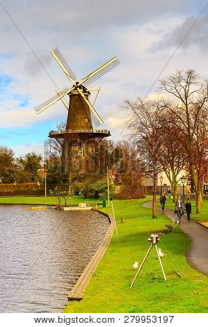 Leiden, Netherlands - April 7, 2016: Windmill De Valk In Leiden, Street Light And Canal, Holland, Ne