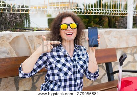 Technology, Emotions And People Concept - Happy Young Woman In Sunny Glasses Show Her Mobile Phone