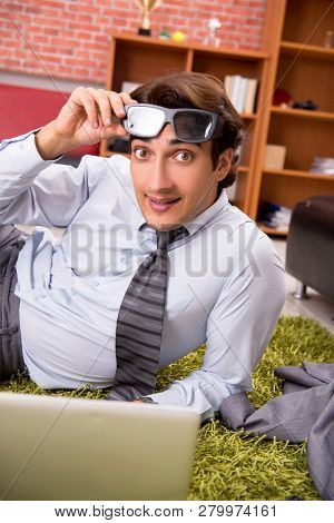 Young employee with virtual glasses during break in the office 