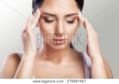 Pain. A Beautiful Woman On A Gray Background, Stress And Headache With Migraine Headaches, She Wrest