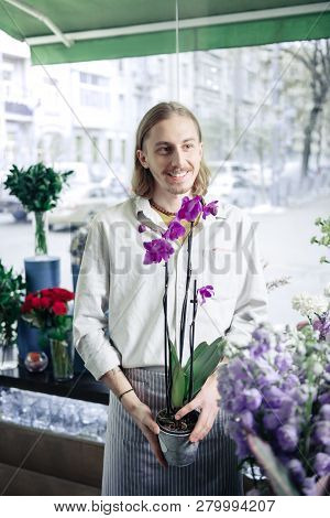 Thoughtful Young Gardener Presenting Unordinary Flower For Clients