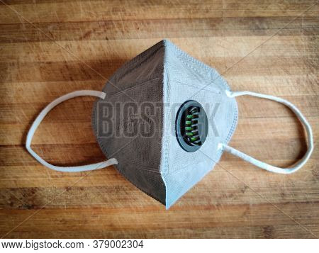 One Grey Color Kn-95 Face Mask Isolated On Wooden Board. Protection From Coronavirus Or Covid-19. We