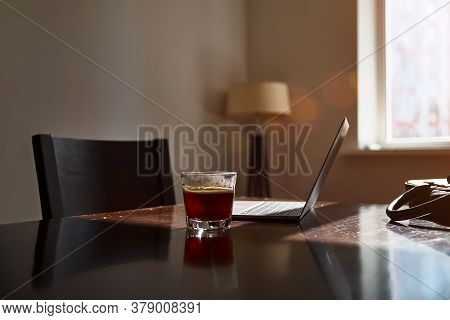 Home Work Place With Laptop, Cup Of Hot Drink On Table Near Window On Sunset Or Sunrise. Freelance, 