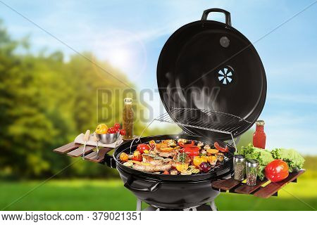 Barbecue Grill With Meat Products And Vegetables Outdoors On Sunny Day