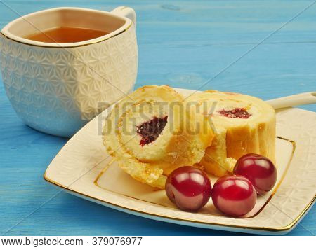 Cup Of Tea, Cream Rolls On A Plate Of Cherries, N In A Blue Background. Proper Nutrition. Lifestyle.