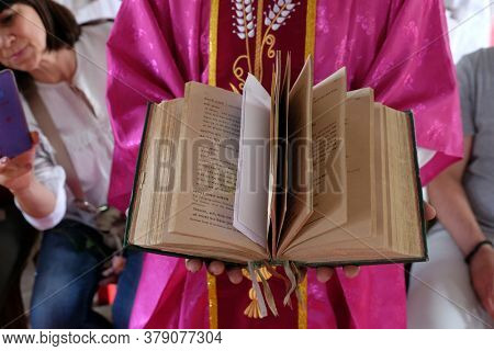 CHUNAKHALI, INDIA - FEBRUARY 26, 2020: The priest holds the missal, Catholic church in Chunakhali, West Bengal, India
