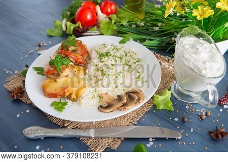 Fired Cordon Bleu Chicken Served With Rice And Parsley On Plate.