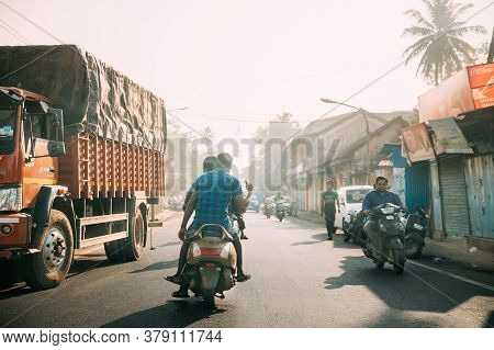 Margao, Goa, India - February 16, 2020: People Riding On Scooters Motorcycle On Street In Sunny Ligh