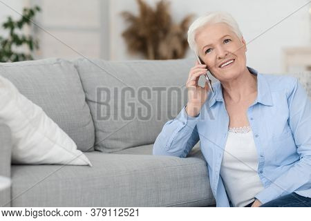 Concierge Services Concept. Smiling Senior Woman Talking On Cellphone With Personal Assistant Manage