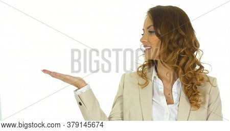 Young business woman presenting sth by a hand. On white background.