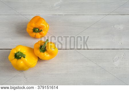 Shaped Yellow Bell Peppers On The Wooden White Background. Misshapen Produce, Food Waste Problem Con