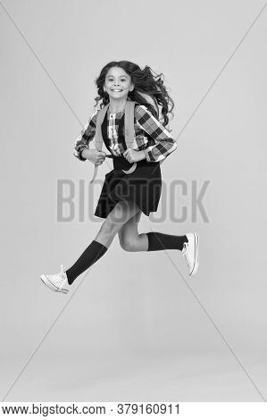 Childhood Activity. Happy Child In Midair Yellow Background. Little Kid Back To School. Childhood De