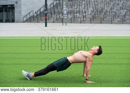 Sporty Man Making Back Plank Exercise. Guy In Reverse Plank Exercise. Yoga Fitness Man Stretching Bo