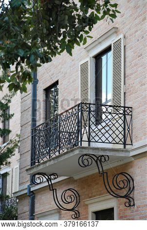 Wrought iron scroll balcony rails with shuttered window