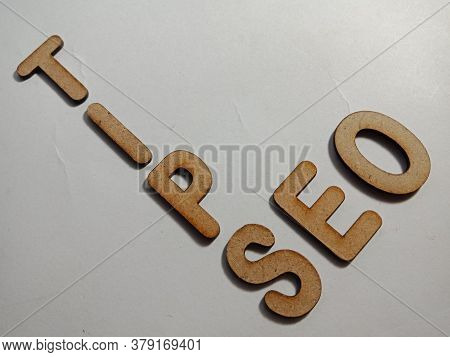 Seo Search Engine Optimization Tips Concept Word Presented On White Surface With Wooden Cross Text C
