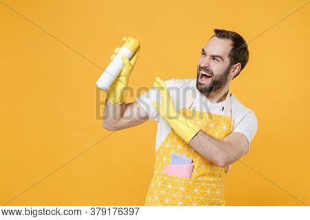 Cheerful Young Man Househusband In Apron Rubber Gloves Hold Spray With Cleaning Polish Cleanser Or A
