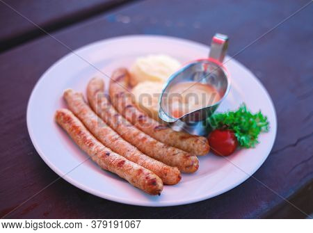 Dish With Bavarian Sausages And Mashed Potatoes With Sauces
