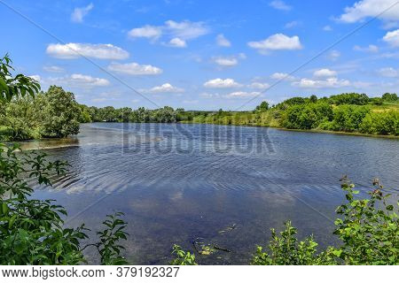 Beautiful Natural Landscape Of A Rural Pond With Lush Green Nature In A Hilly Area. Spring-summer Pa
