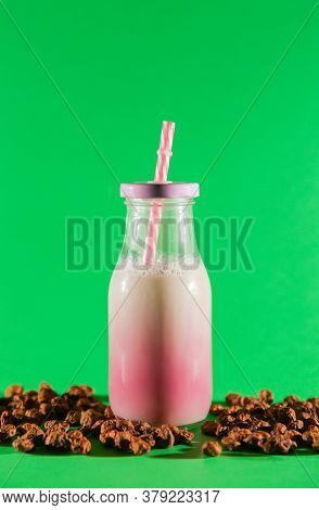 Tigernut Milk In A Pink Glass Jar. Pieces Of Tigernut, Green Background.