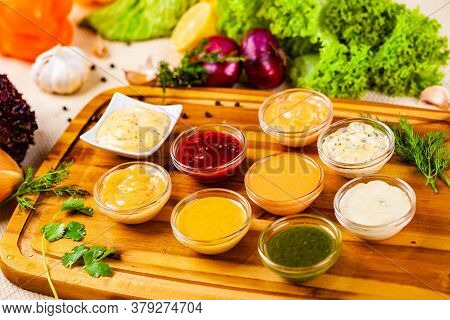 Different Sauces Assortment On Wooden Cutting Board
