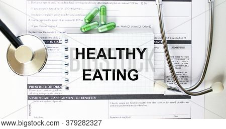 Text Healthy Eating In A Notebook On Medical Forms With A Phonendoscope And Green Pills