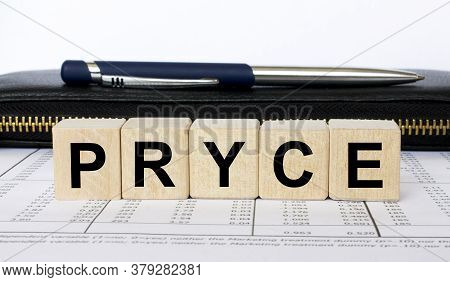 A Word Pryce Written In A Wooden Cube With A Pen And Wallet