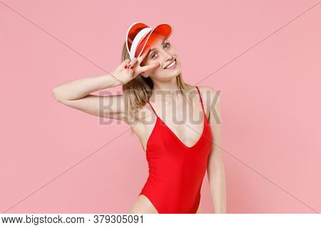 Smiling Young Blonde Woman Girl In Red One-piece Swimsuit Cap Posing Isolated On Pastel Pink Backgro