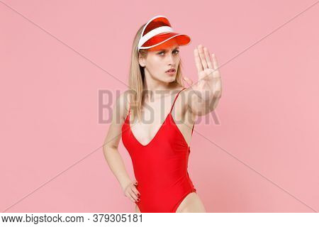 Concerned Young Blonde Woman Girl In Red One-piece Swimsuit Cap Posing Isolated On Pink Background. 
